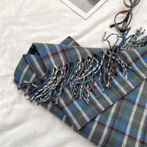 Detail of gray and blue plaid scarf showing soft knit texture and fringe tassels