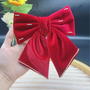 Dettaglio del fiocco in velluto rosso con frangia di strass di lusso e accenti luminosi