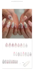 Close-up of pink gradient press-on nails with 3D silver stars, pearls and bows