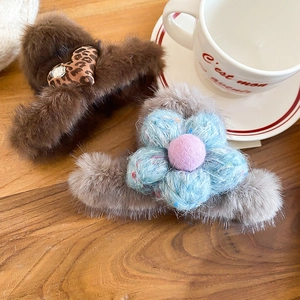 Detailed view of plush hair claws with leopard heart and 3D wool flower accents