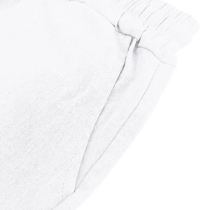 Detail of white linen shorts showing elastic waistband, side pocket, and woven texture