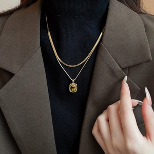 Double-layered gold snake chain necklace with square tiger eye pendant on a model