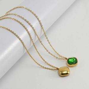 Detail of 18K gold stainless steel necklace with green zircon and geometric square pendant