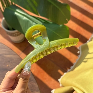 Close-up of a large avocado green butterfly hair claw clip with a glossy finish