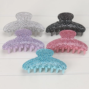 Detail of five acrylic hair claws with sparkling rhinestones in assorted vibrant colors
