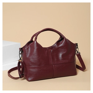 Detailed close-up of wine red soft leather handbag featuring stitching and refined texture
