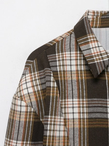 Détail du col et de l'épaule de la chemise à carreaux marron, verte et orange