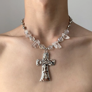 Silver cross pendant necklace with crystal beads and fish relief on a female model