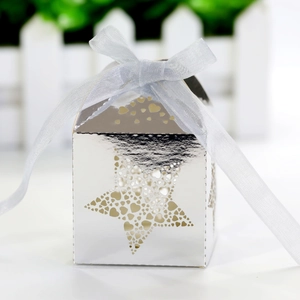 Macro detail of silver star-shaped laser cut candy box with white ribbon tie decoration