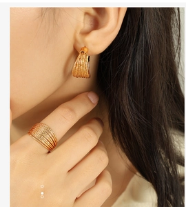 Details von Model mit goldenen mehrschichtigen Ohrringen und Ring mit feiner Textur