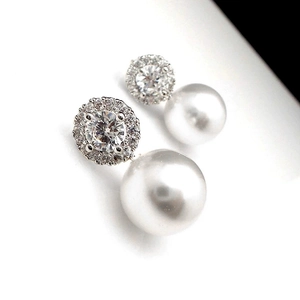 Macro shot of micro-paved zircon stud earrings with high-luster round white pearls