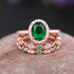 Macro view of rose gold plated ring set with oval green gemstone and halo diamonds