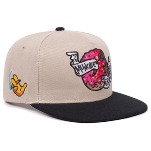 Detailansicht beige Flat-Brim-Kappe mit besticktem Donut-Cartoon und Munchie-Banner.
