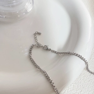 Detalle de cadena ajustable de plata con cierre de langosta y colgante de gota