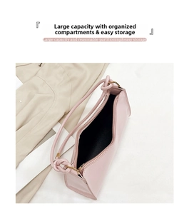 Pink faux leather baguette bag showing interior storage space and metal zipper detail