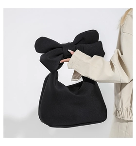 Fashionable black nylon puffer handbag featuring a unique large bow handle design