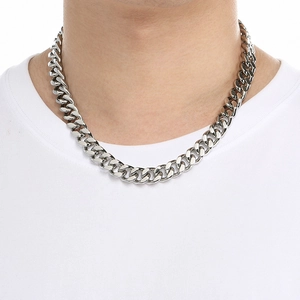 Close-up of classic silver Cuban link chain necklace on model wearing white shirt