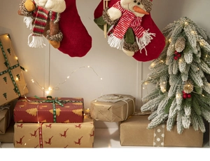 Festive Christmas stockings with plush reindeer and snowman decor near a mini pine tree