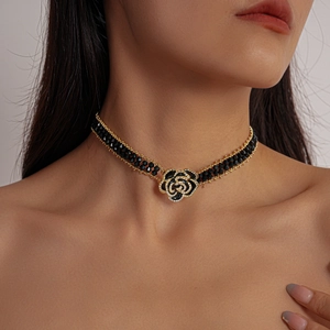 Macro detail of gothic rose choker with black beads and gold-tone floral crystal pendant