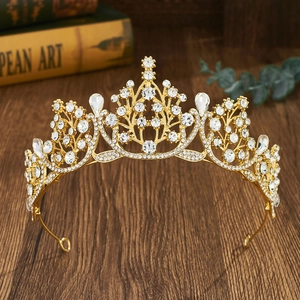 Close-up of golden baroque tiara with water-drop crystals on a vintage wood surface