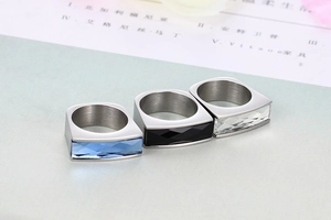 Detailed view of three stainless steel rings with blue black and clear crystal inlays