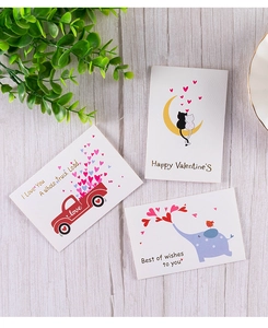 Flat lay of three gold foil Valentine's Day cards on a wooden surface with greenery