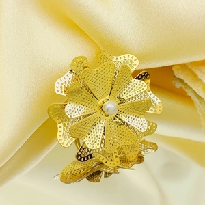Detailed macro view of layered gold hollow flower petals with a central pearl inlay