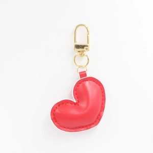Detailed close-up of a red heart-shaped PU leather keychain with gold metal ring