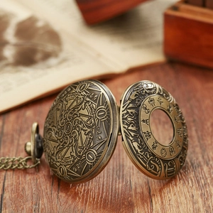 Close-up of vintage bronze pocket watch with intricate embossed patterns on wood