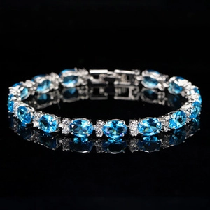 Gros plan d'un bracelet en argent serti de pierres bleues ovales et zircons brillants