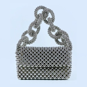 Detailed view of silver metallic beaded evening bag with chunky ring chain handle