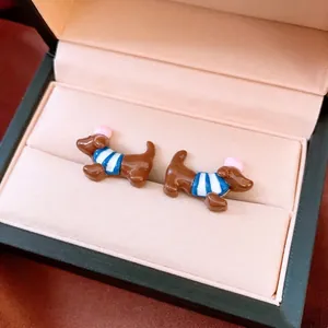 Süße Dackel-Ohrstecker aus braunem Emaille mit blau gestreiftem Shirt in einer Box