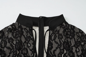 Close-up of black lace dress showing detailed floral mesh texture and neckline zipper