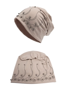 Close-up of khaki beanie featuring elegant rhinestone scroll patterns and bead details