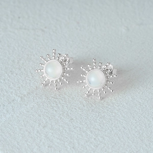 Macro shot of S925 sterling silver opal stud earrings with sunburst design detail