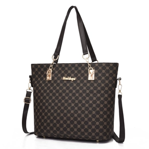 Detail view of deep brown tote bag with geometric monogram print and gold hardware
