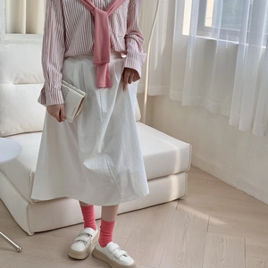 Details of pink mid-calf socks paired with white sneakers and a striped shirt outfit