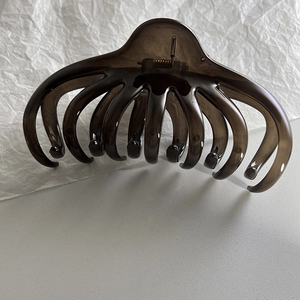 Detail view of large dark coffee translucent octopus hair claw with strong metal spring