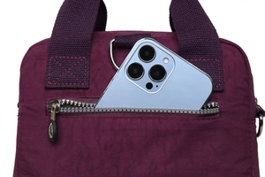 Détail de la poche zippée d'un sac en nylon avec un smartphone pour l'échelle