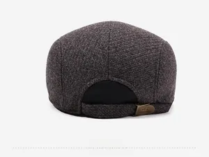 Detail of winter wool newsboy cap showing tweed texture and metal buckle on the back