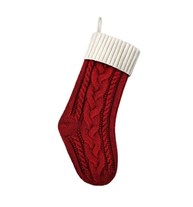 Dettaglio calza natalizia in maglia rossa con risvolto bianco a coste e gancio