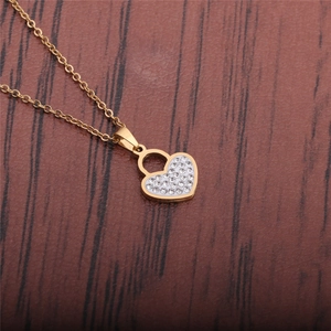 Dettaglio della collana con lucchetto a cuore dorato e strass bianchi su legno