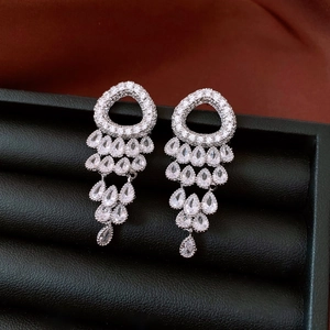 Macro shot of silver tassel earrings with zircon studs and hanging waterdrop gems