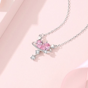 Pink heart-shaped zircon planet necklace with silver chain for women on soft pink background