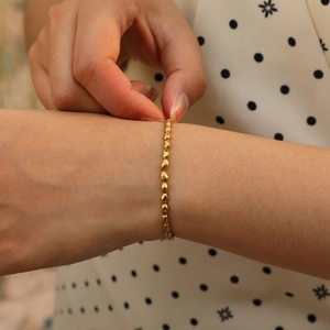 Close-up of faceted gold beaded bracelet on wrist with elegant minimalist style