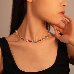 Close-up of a vintage luxury drop-shaped necklace with colorful gemstones on a model's neck