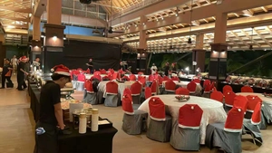 Classic red Christmas hat chair covers decorating chairs in a festive banquet hall setting