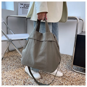 Macro shot of army green nylon tote bag featuring durable handles and casual texture