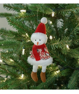Dettaglio di un pupazzo di neve di peluche su un albero di Natale con luci calde