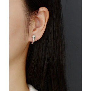 Close-up of S925 sterling silver snake hoop earring with green stone eyes on model